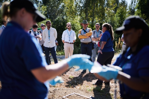 High-level visitors observing field team carrying out environmental sampling