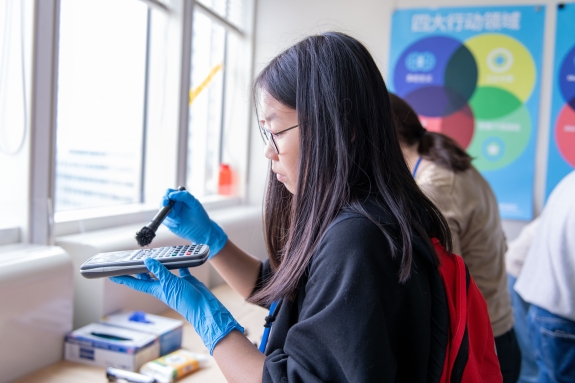 Participant dusting for fingerprints in workshop during Daughters’ Day 2023