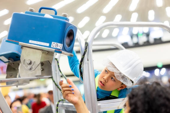 Child interacting with equipment at International Atomic Energy Agency (IAEA) booth