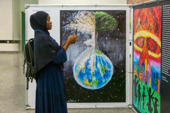 Visitor taking photograph of artwork displayed at exhibit 