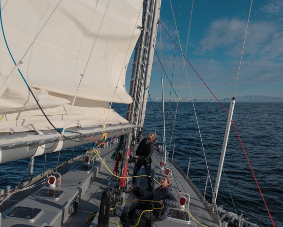 First Mate Eoin Keyes and Crew Luca Novak raising mainsail in Gerlache Strait, Antarctica