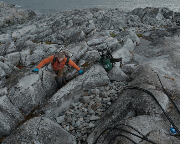 First Mate Eoin Keyes helping IS54 installation team carry gravel from shore up to H4 installation site